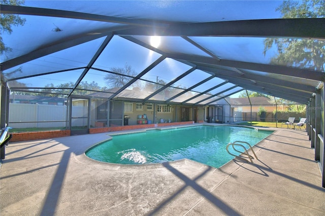 view of swimming pool featuring a patio, a lanai, and a storage shed