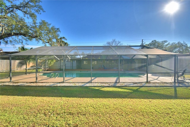 view of swimming pool featuring a lanai and a lawn