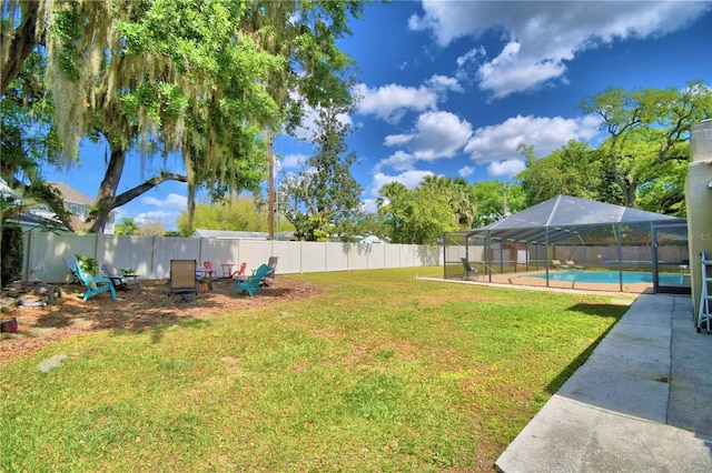 view of yard featuring a fenced in pool and glass enclosure