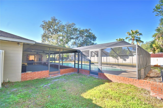 exterior space with a fenced in pool, ceiling fan, and glass enclosure