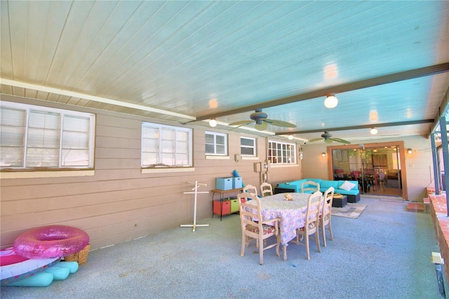 playroom featuring beam ceiling, carpet floors, wooden walls, and ceiling fan