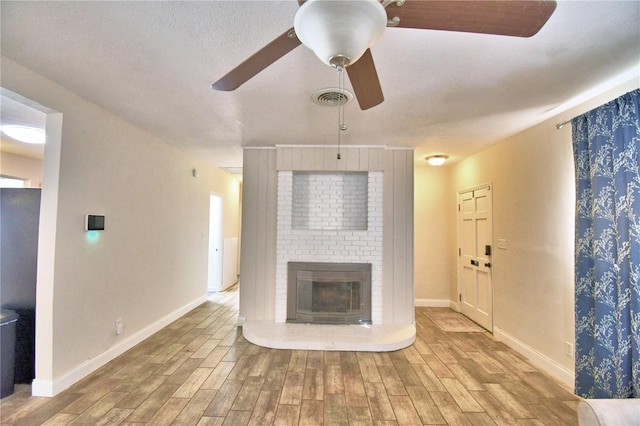 unfurnished living room featuring ceiling fan and a fireplace