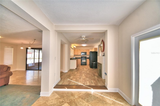 hall featuring sink, light colored carpet, and a textured ceiling