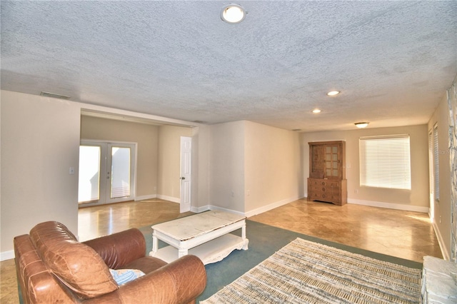 living room with french doors and a textured ceiling