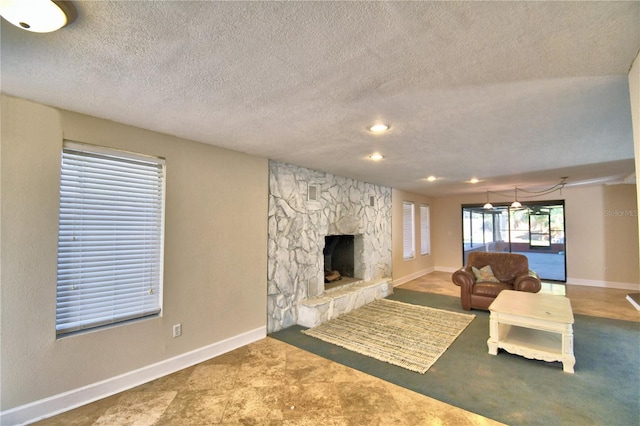 living room featuring a stone fireplace and a textured ceiling