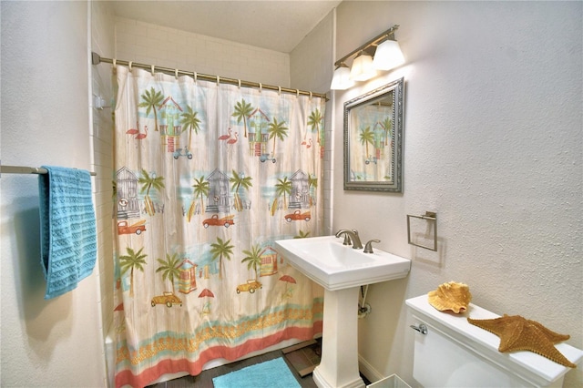 bathroom featuring shower / bathtub combination with curtain and toilet