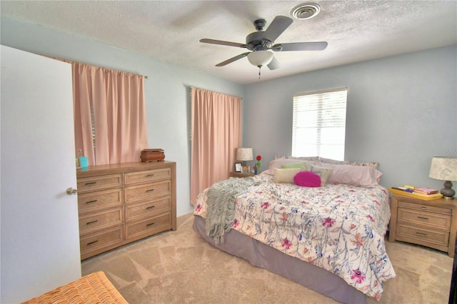 carpeted bedroom featuring a textured ceiling and ceiling fan