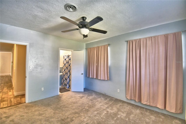 unfurnished bedroom featuring a spacious closet, carpet floors, a closet, and ceiling fan