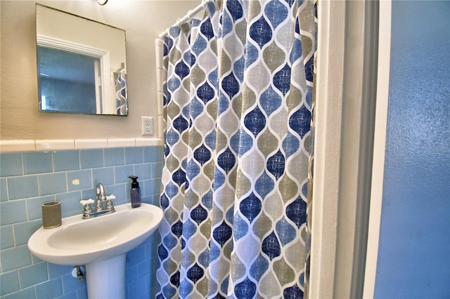 bathroom with sink and tile walls