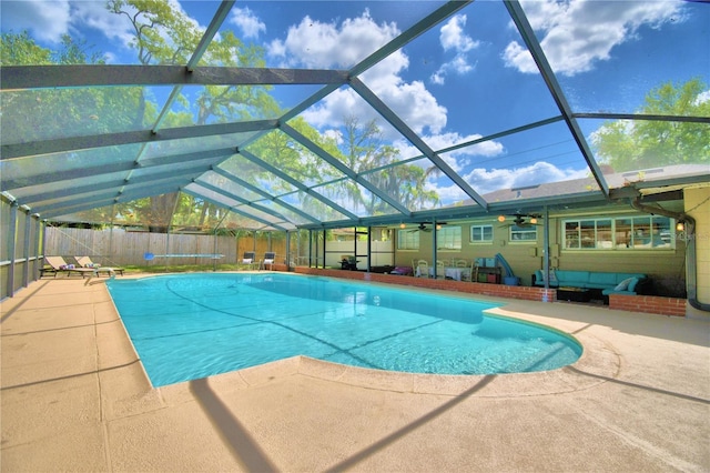 view of swimming pool with a patio, ceiling fan, and glass enclosure