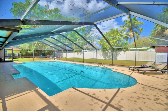 view of swimming pool featuring a patio, a lanai, and a lawn