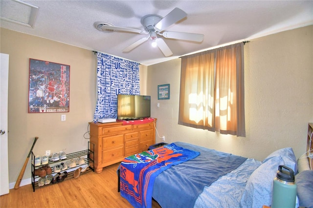 bedroom featuring a textured ceiling, wood-type flooring, and ceiling fan