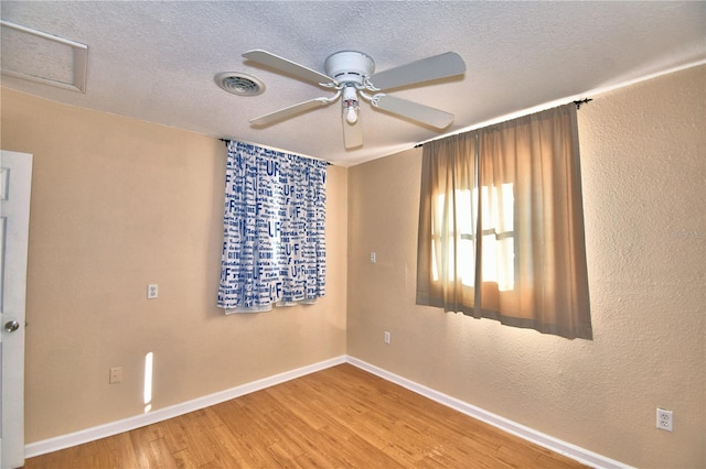 empty room featuring wood-type flooring, a textured ceiling, and ceiling fan