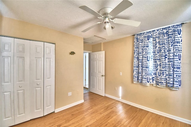 unfurnished bedroom with ceiling fan, light hardwood / wood-style floors, a closet, and a textured ceiling