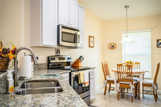 kitchen featuring sink, appliances with stainless steel finishes, light stone counters, and white cabinets