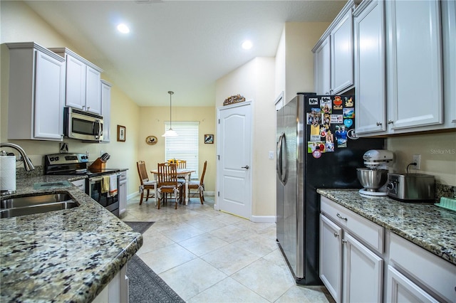 kitchen featuring hanging light fixtures, stainless steel appliances, sink, stone counters, and white cabinets