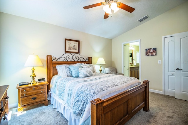 carpeted bedroom featuring ensuite bath, vaulted ceiling, a textured ceiling, and ceiling fan