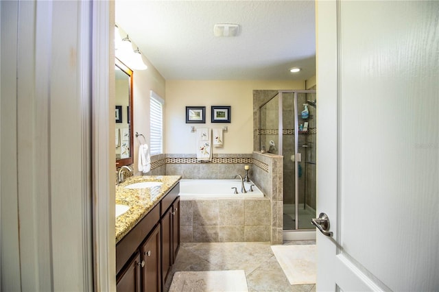 bathroom featuring vanity, tile patterned floors, a textured ceiling, and plus walk in shower