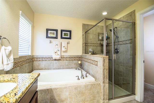 bathroom featuring vanity, plus walk in shower, and a textured ceiling