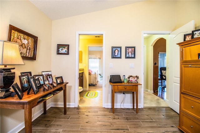 hallway with lofted ceiling and dark hardwood / wood-style floors