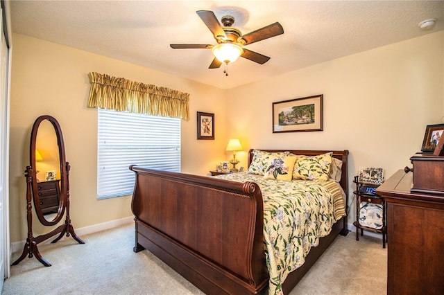 carpeted bedroom with a textured ceiling and ceiling fan