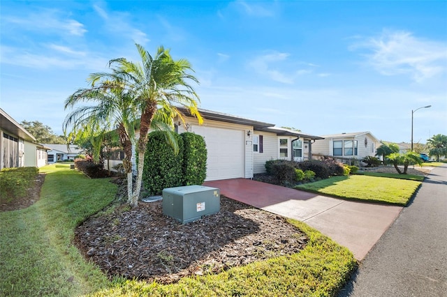 ranch-style home with a garage and a front lawn