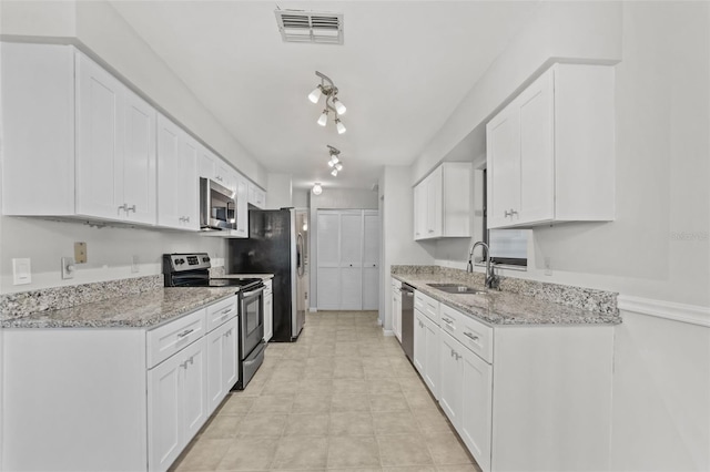 kitchen featuring white cabinetry, visible vents, stainless steel appliances, and a sink