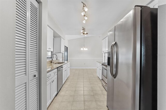 kitchen featuring white cabinetry, a sink, appliances with stainless steel finishes, a chandelier, and baseboards