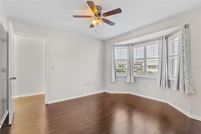 unfurnished room with a ceiling fan, wood finished floors, and baseboards