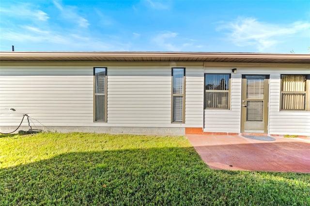rear view of house featuring a yard and a patio area