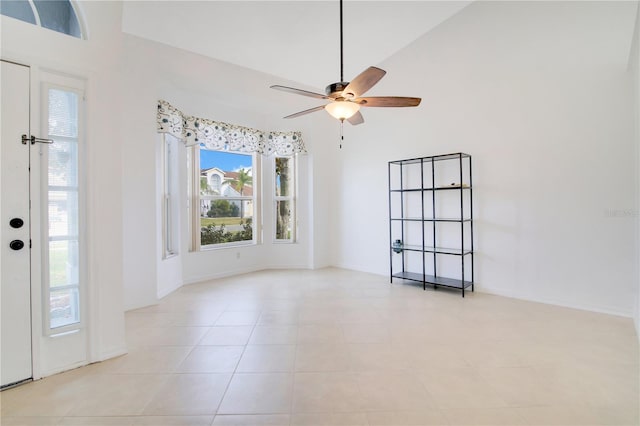 tiled spare room featuring high vaulted ceiling and ceiling fan