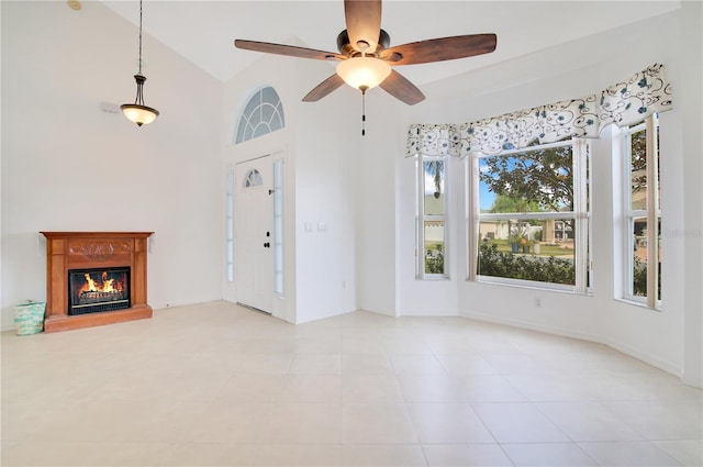 unfurnished living room featuring high vaulted ceiling and ceiling fan