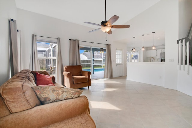 tiled living room featuring a wealth of natural light, sink, high vaulted ceiling, and ceiling fan