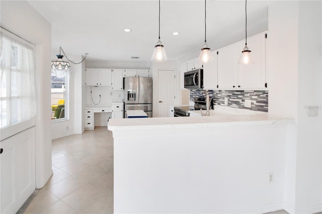 kitchen with appliances with stainless steel finishes, backsplash, kitchen peninsula, white cabinetry, and pendant lighting