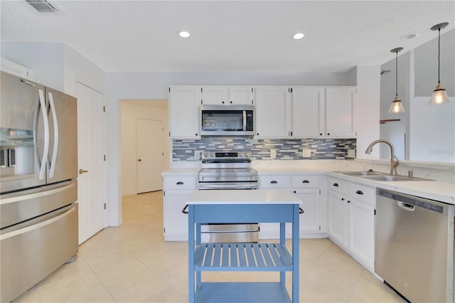 kitchen with sink, a textured ceiling, white cabinetry, stainless steel appliances, and decorative light fixtures