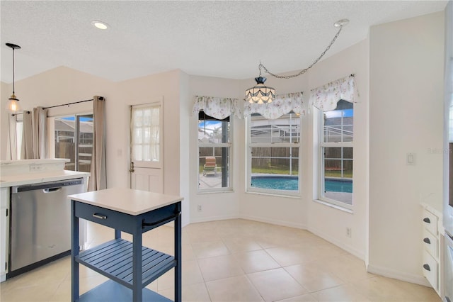 kitchen with pendant lighting, white cabinetry, a wealth of natural light, and stainless steel dishwasher