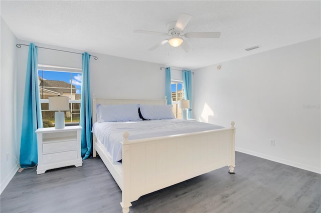 bedroom featuring dark wood-type flooring, ceiling fan, and a textured ceiling