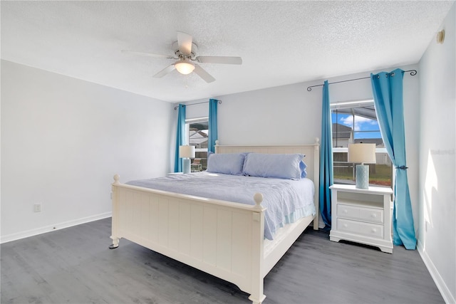 bedroom with dark wood-type flooring, ceiling fan, and a textured ceiling