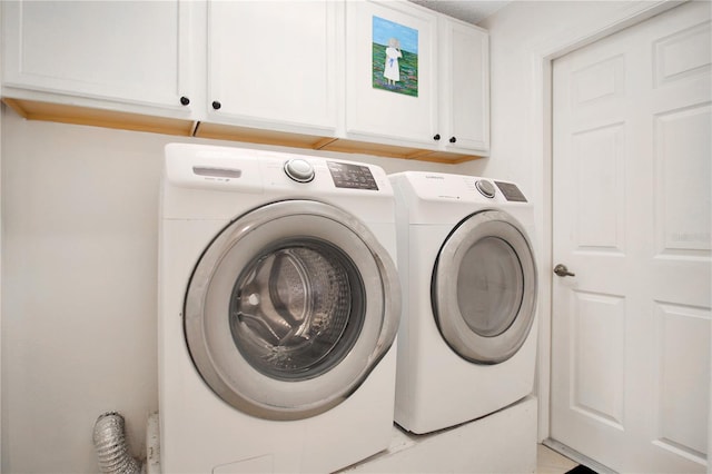 washroom featuring cabinets and washer and clothes dryer