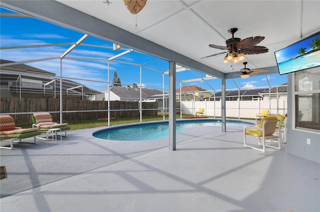 view of pool featuring ceiling fan, glass enclosure, and a patio area