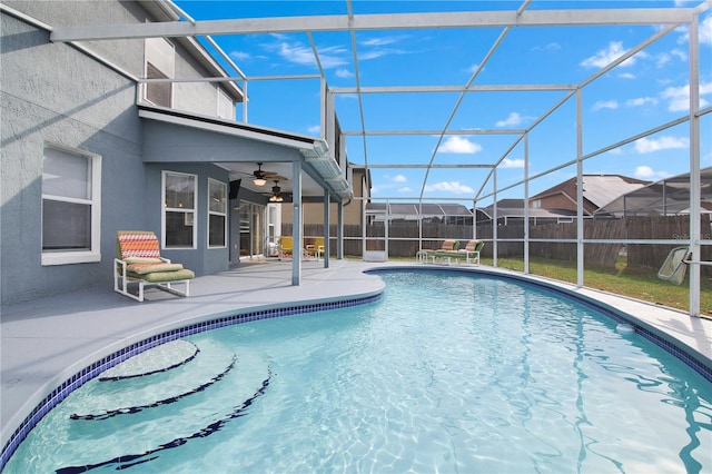 view of pool featuring a patio area, glass enclosure, and ceiling fan