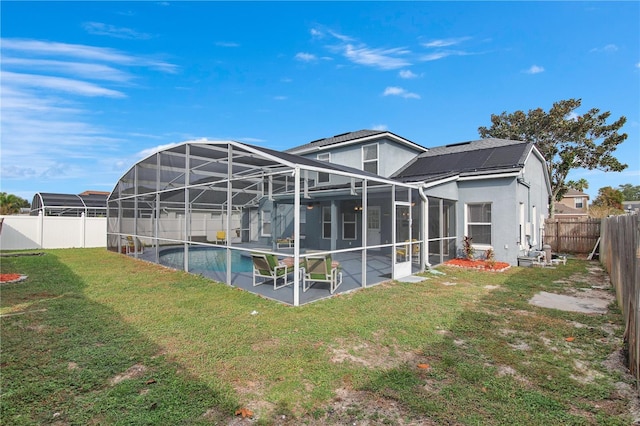 back of property featuring a patio, a fenced in pool, a lanai, and a yard