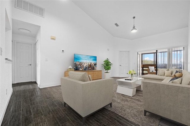 living room featuring dark wood-type flooring and a high ceiling