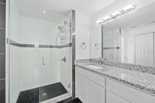 bathroom with vanity and a shower with shower door