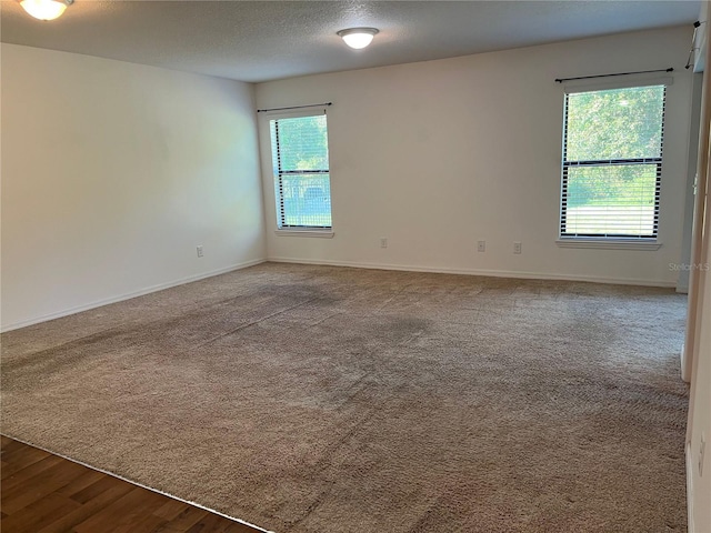 empty room with a textured ceiling and hardwood / wood-style flooring