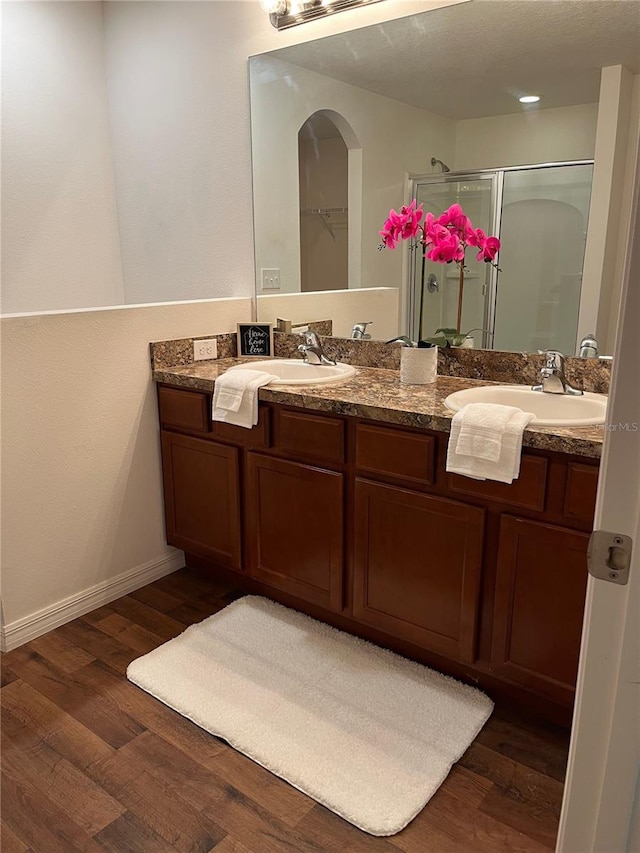 bathroom featuring vanity, a shower with shower door, and wood-type flooring