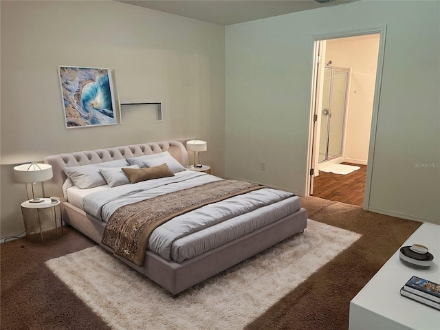 bedroom featuring ensuite bathroom and carpet flooring