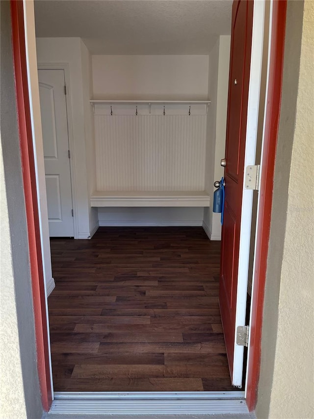 mudroom featuring dark wood finished floors and baseboards