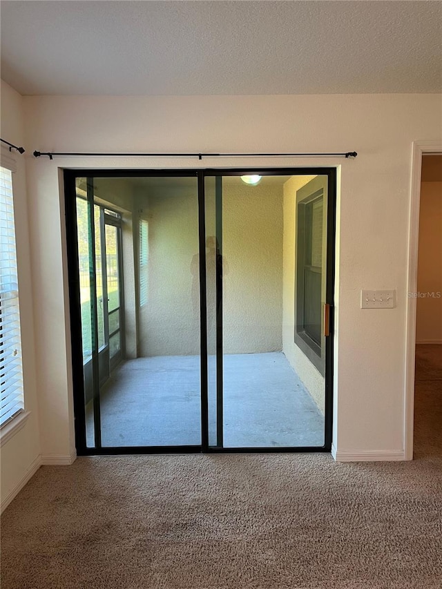 interior space with carpet, a textured ceiling, and baseboards