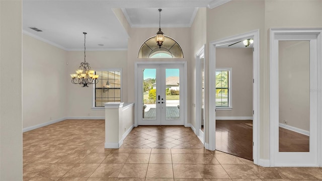 entrance foyer featuring french doors, crown molding, a notable chandelier, and light wood-type flooring